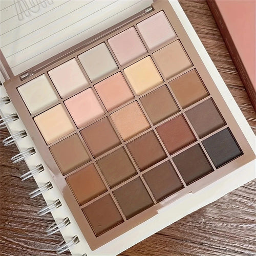 Makeup palette with various neutral shades on a wooden surface